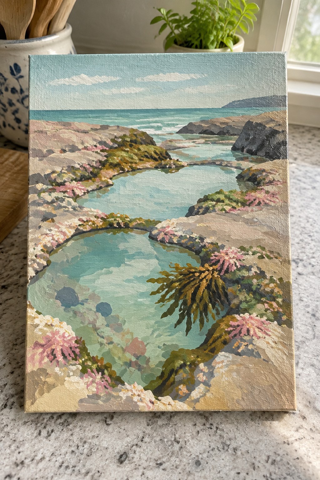 Coastal painting with turquoise tidal pools, pink flowers, rocky cliffs, and ocean waves.