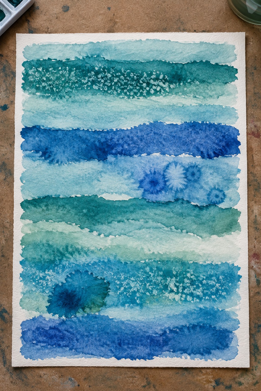Watercolor painting with layered blue and teal horizontal stripes and splatters