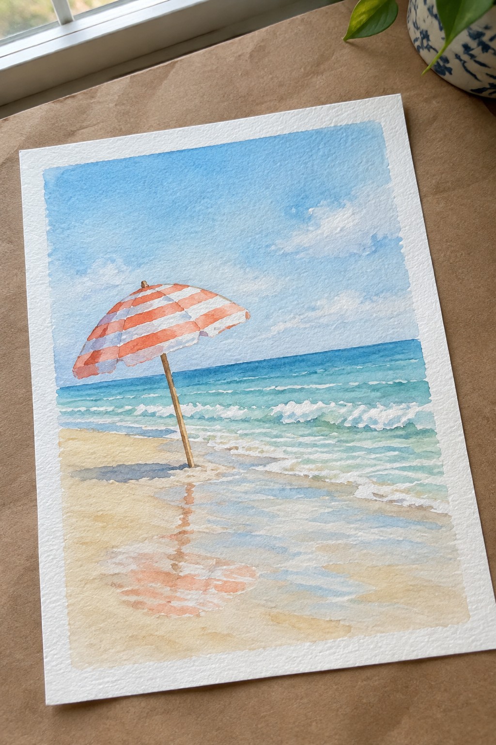 Watercolor of red-white striped umbrella on beach with turquoise waves under blue sky