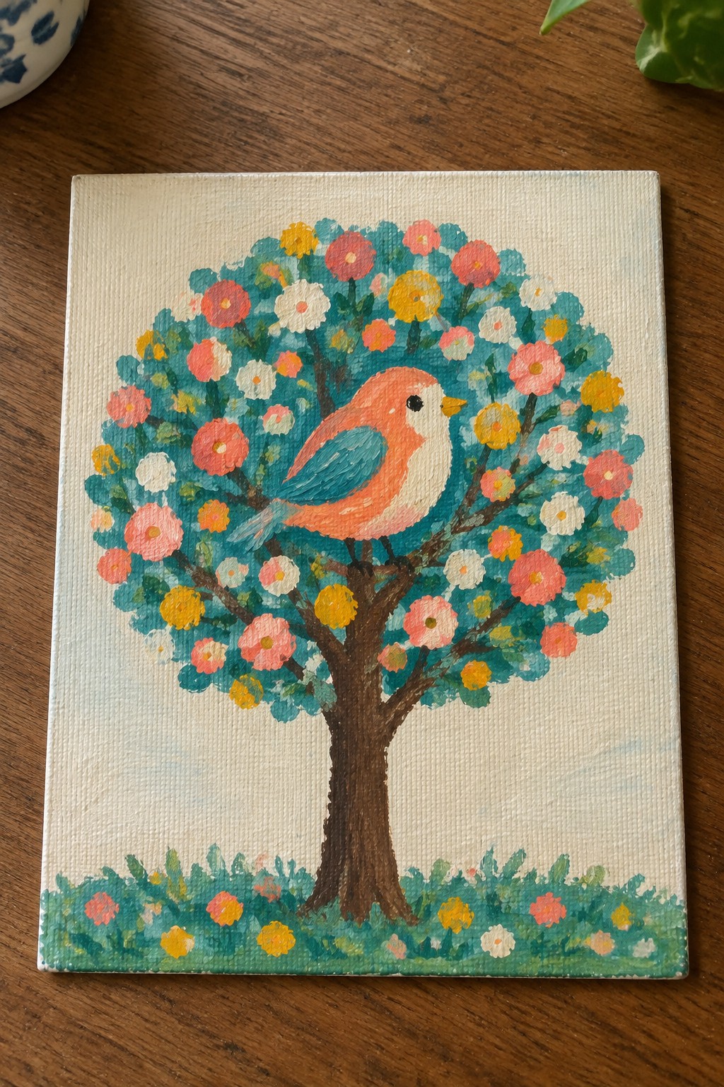 Vibrant acrylic painting of a flowering tree with an orange bird on canvas