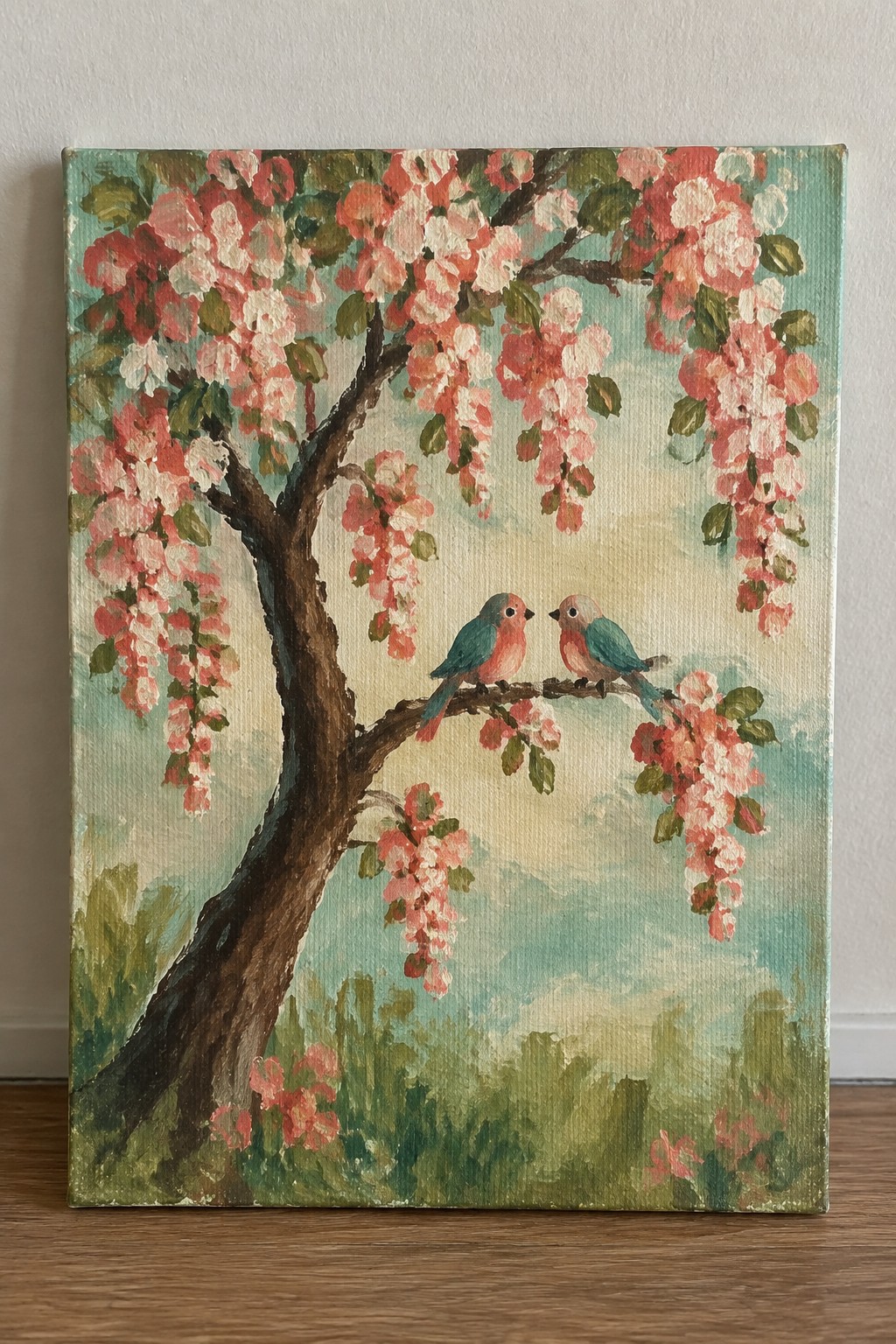Canvas painting of pink blossoming tree with two colorful birds on branch