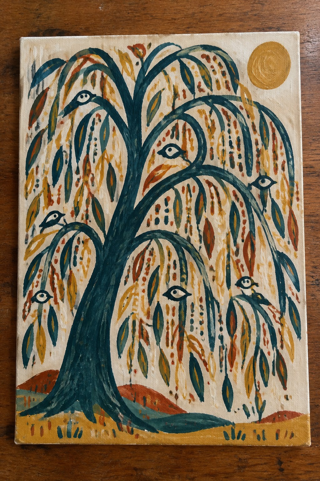 Colorful folk painting of tree with eyes, birds, and golden sun on canvas.