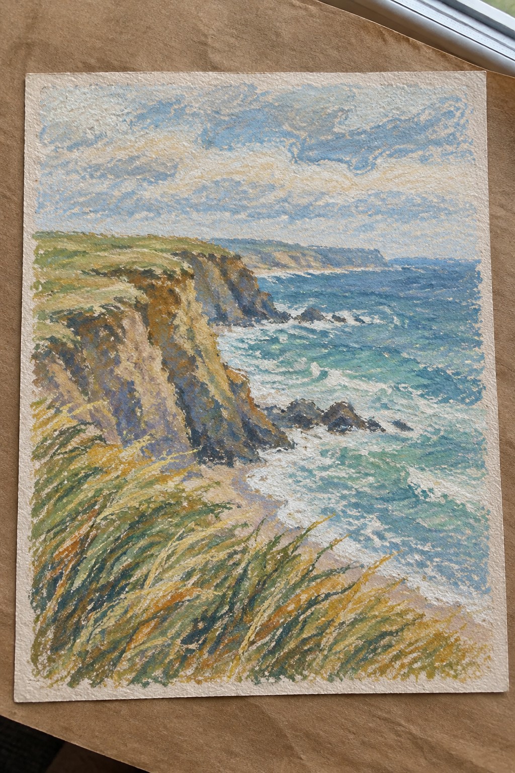 Watercolor seascape of grassy brown cliffs overlooking crashing blue waves and distant headlands