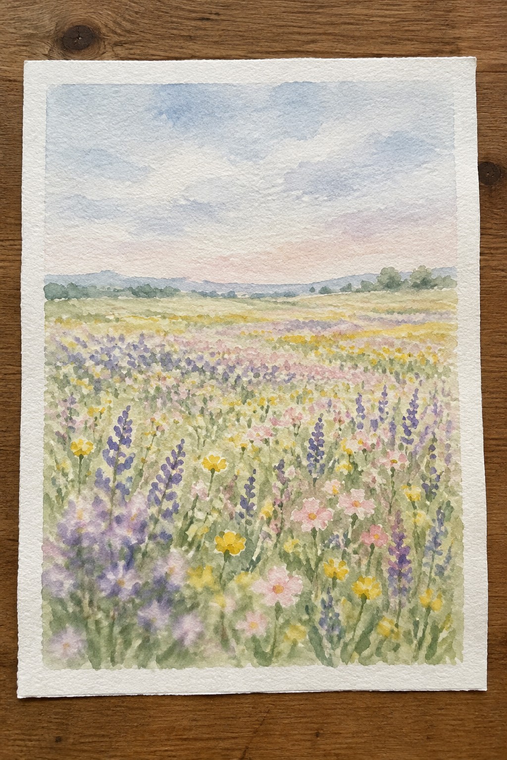 Watercolor painting of vibrant wildflower meadow with purple, pink, yellow blooms under soft sky