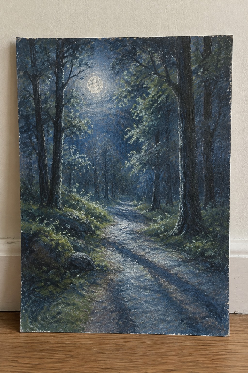 A painting of a moonlit dirt path winding through a dark forest with tall trees and a bright full moon overhead.